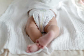 4 months old baby wearing diapers lying on the bed