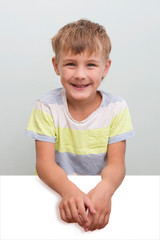 Portrait of happy joyful laughing kid boy  on a gray background. school boy looking at camera. primary school education.