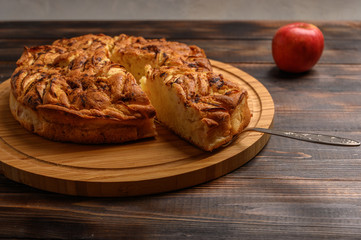 Cornish apple pie with a cut piece on the shoulder blade top view on rustic style brown background. Copy space for your text