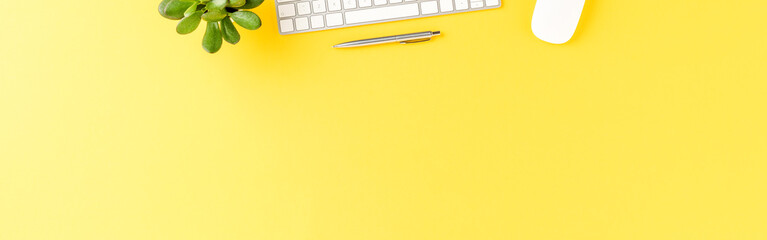 Elegant office desktop with computer keyboard and pen on yellow table. Business background with copyspace. Banner