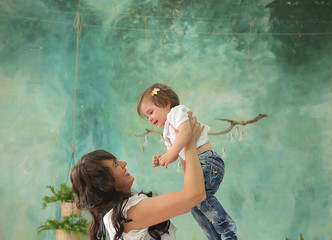 Obraz na płótnie Canvas mom and little cute daughter in a white dress in a spring photo studio