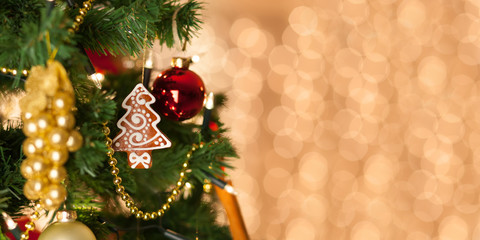 Christmas gingerbread decoration on a christmas tree. Background of de-focused lights. Christmas decoration on christmas tree. Winter holidays. Copy space