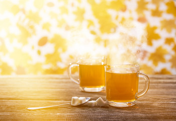 Couple cups of hot tea  on a autumn leaves background