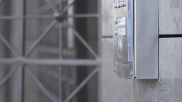 woman hand opens grate porch door with intercom key