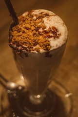 Espresso with Vanilla milkshake topped with tiramisu cake, chocolate sauce, whipped cream and speculoos biscuit