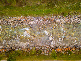 Aerial view of riverbed in Switzerland. Top view of water flowing downstream.