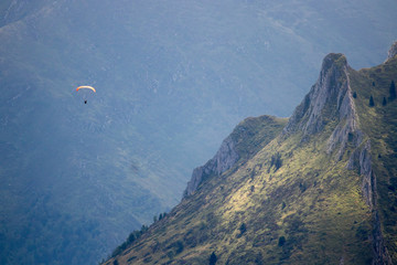 man with paraglider flying among the mountains