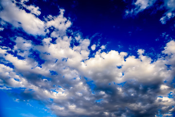 Beautiful puffy clouds with sun beams against blue skies.  
