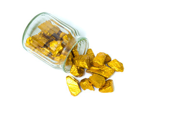 Gold nuggets or gold ore and glass jar isolated on white background.