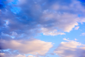 Beautiful puffy clouds with sun beams against blue skies.  