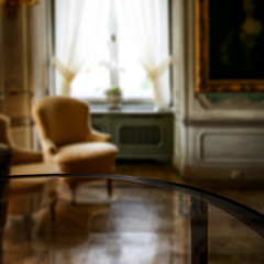 Glass table top with blurred luxury home interior. Table background with empty space for products and decorations.