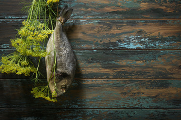 Fish hanging on the background of an old painted wooden blue wall.