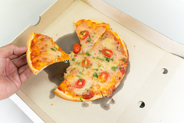 hand picking up a lice of pizza lunch or dinner crust meat topping sauce with bell pepper -...