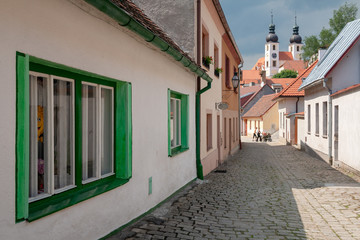 Fototapeta na wymiar Street view with the St. James church in the background at the city of Telc, Vysocina Region, CZ