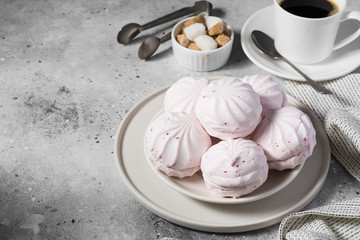 Pink marshmallows with blackcurrants on a plate. Light grey background