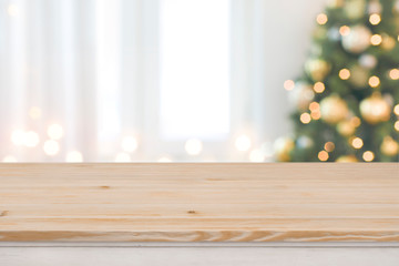 Christmas tree defocused background with wooden table in front