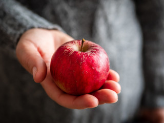 Frau über 40 mit einem roten Apfel in ihrer Hand, Nahaufnahem, Winter