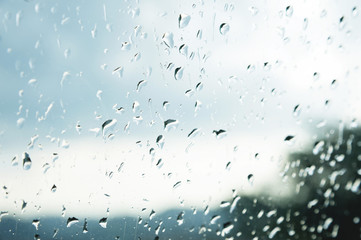 Natural background Drops on both sides of the glass from the rain and from the fogging abstract view, raindrops against the blue glass and the blurred landscape of the gradient of blue and green