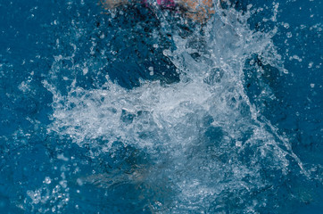 Splash and spray of water in the pool. Abstract background and texture.