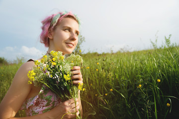 Portrait of a young happy smiling girl in a cotton dress with a bouquet of wildflowers