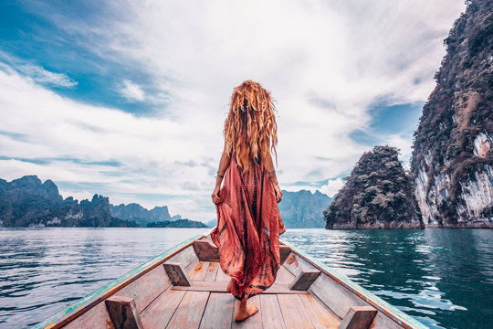 Fototapeta fashionable young model in boho style dress on boat at the lake