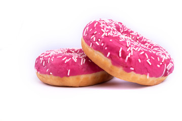 Side view of two donuts with pink frosting and white sprinkles