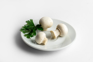 Heap of champignons on plate isolated on white background. Sliced mushrooms top view