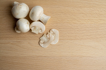 Fresh champignon mushrooms on wood