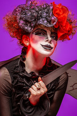 A closeup of a scarier clown female Holding Knife