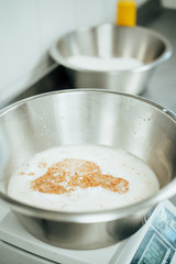 Male baker prepares dough for baking grain bread with flax seeds