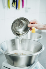 Male baker prepares dough for baking grain bread with flax seeds