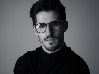 Obraz premium Young attractive latin man with glasses posing looking sensual and handsome. Beauty concept and lifestyle