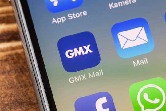 METTINGEN, GERMANY - NOVEMBER 9, 2018: Close up to GMX Mail app on the screen of an iPhone X with personalized background