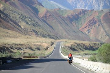Long distance cycling on M41 Pamir Highway near Uch-Tyube, Kyrgyzstan
