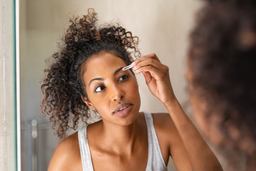 African woman plucking eyebrows