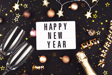 New Year composition with confetti, decorations and champagne.