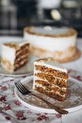 beautiful Healthy Homemade Carrot Cake on plate on the background of a blurred whole cake on a stand