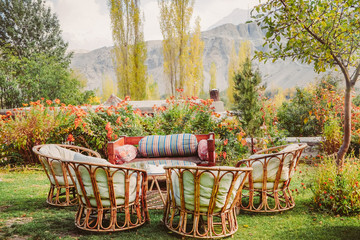 Eco living style garden with local wooden furniture surrounded by beautiful flowers and trees in Shigar. Gilgit Baltistan, Pakistan.