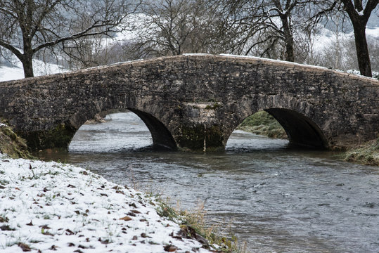 un vieux pont jura en pierre médiéval en hiver avec neige et rivière