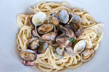 Spaghetti with clams. Pasta with clams. Typical dish of Italian cuisine. Typical Italian first courses. Spaghetti with seafood. Flat lay.
