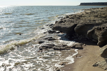 Autumn rocky sea shore illuminated by the rays of the sun