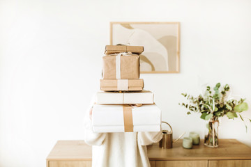 Young pretty woman holding Christmas / New Year gift boxes with bows. Winter holidays gifts...