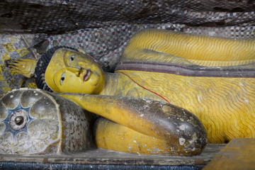 Statue of reclining Buddha in the ancient Buddhist cave temple at Dambulla, Sri Lanka.