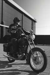 Black and white. Portrait of a middle-aged man, an old biker in a leather jacket on a retro bike, vintage classic Soviet motorcycle. concept of freedom and style, a hobby for life. vertical photo