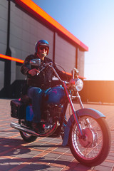 Soft light. Portrait of a middle-aged man, an old biker in a leather jacket on a retro bike, vintage classic Soviet motorcycle. concept of freedom and style, a hobby for life. vertical photo