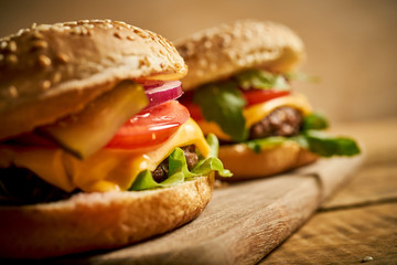 Close up of tasty hamburger on wooden table and black background