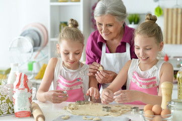 Obraz na płótnie Canvas Portrait of cute girls and mother baking
