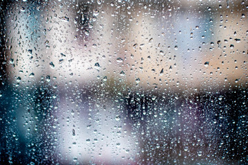 City in blur behind glass during the rain. Misted glass.