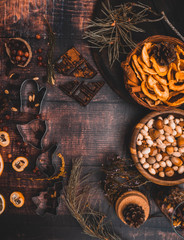 Food background with christmas spices, dried apples, nuts, citrus fruits, cydonia, cranberries, raisin, and baking dish on wooden background.Top view with copy space
