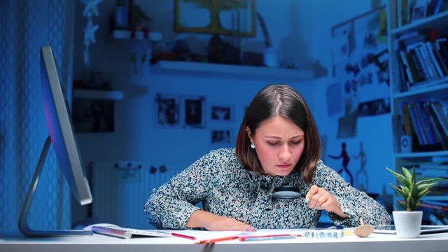 A criminalist in police sitting at a table working at a computer.